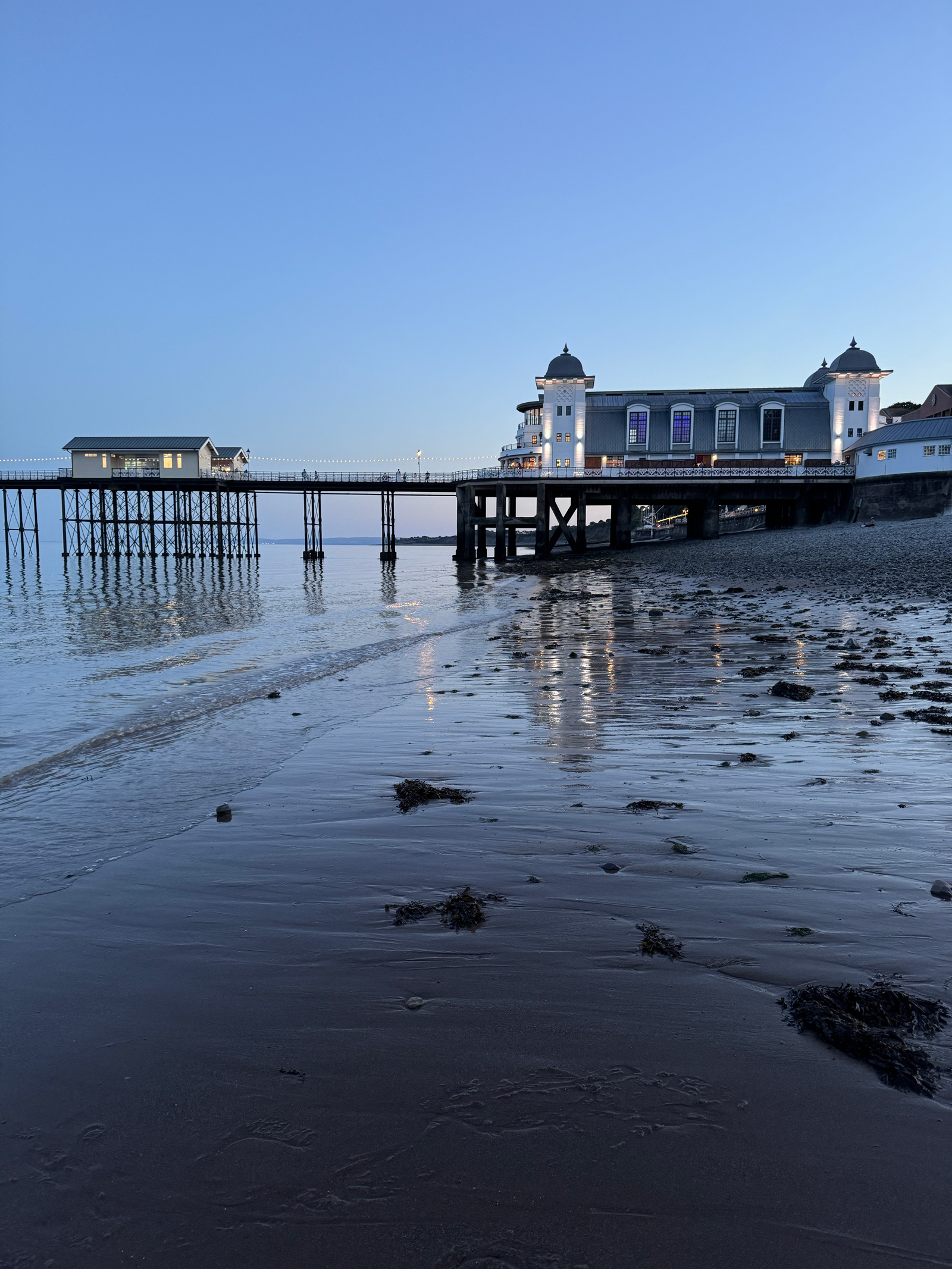 Penarth Pier on a summer evening, blue hour reflections on wet sand